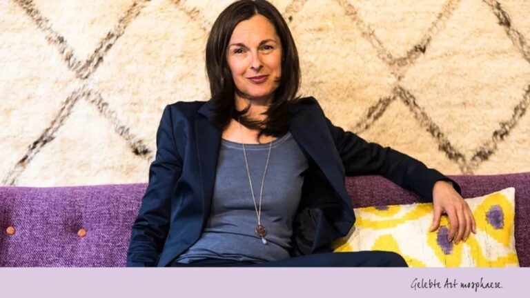gabriele pühringer sitzt auf einem lila sofa