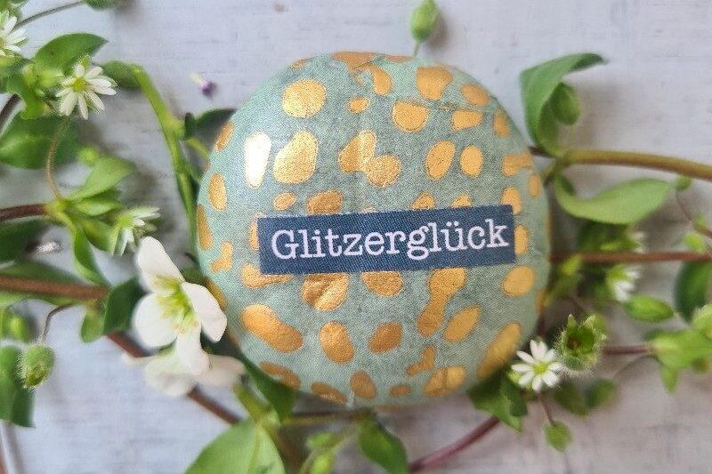 kleiner glitzernder glücksstein und blumen