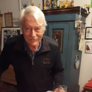 weisshaariger mann vor einem bauernkasten