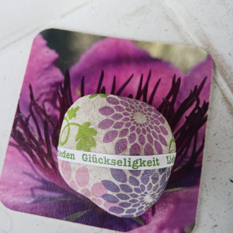 Stein mit Blumen Muster mit Worten Glückseligkeit Frieden Liebe