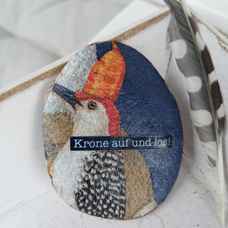 vogel mit krone auf einem stein